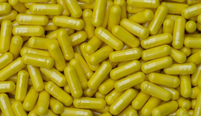 Vivid yellow berberine capsules clustered together, highlighting the supplement's use for glucose metabolism and cardiovascular health support.
