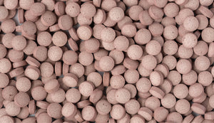 A dense array of pinkish-brown astaxanthin tablets, emphasizing the supplement's role in supporting skin health and overall antioxidant protection.