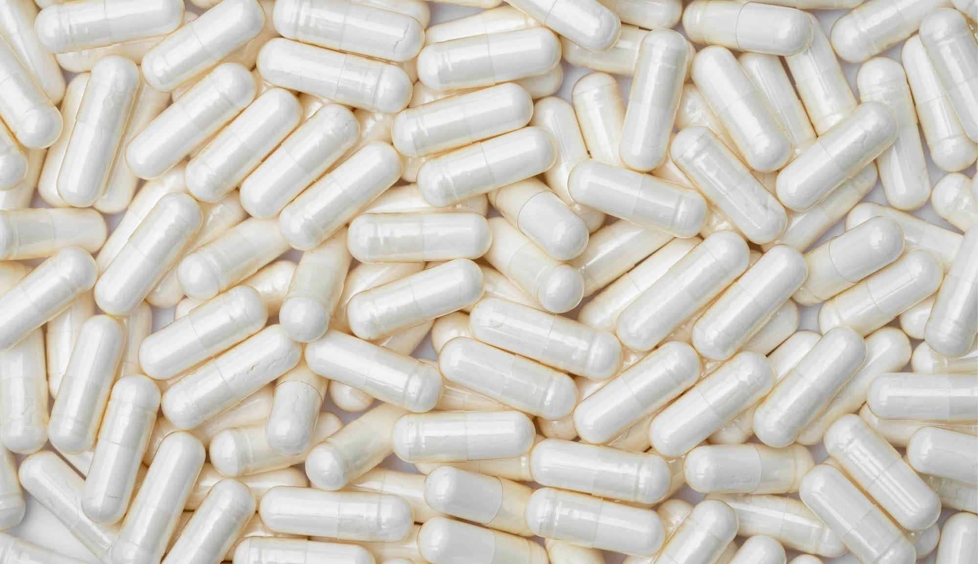 A dense array of white citicoline capsules filling the frame, typically used as a nootropic to support cognitive functions and brain health.