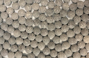 Top view of numerous uniform DGL licorice tablets neatly arranged, showcasing the speckled texture of the supplements known for supporting digestive health.